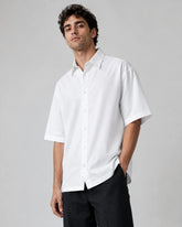 Male model wearing RENQARA White Flow Collar Shirt, oversized half-sleeve cotton shirt styled with black trousers for clean everyday wear.
