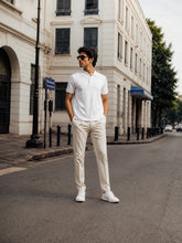 Full-body view of the RENQARA White Polo T-Shirt styled with cream trousers and white sneakers.