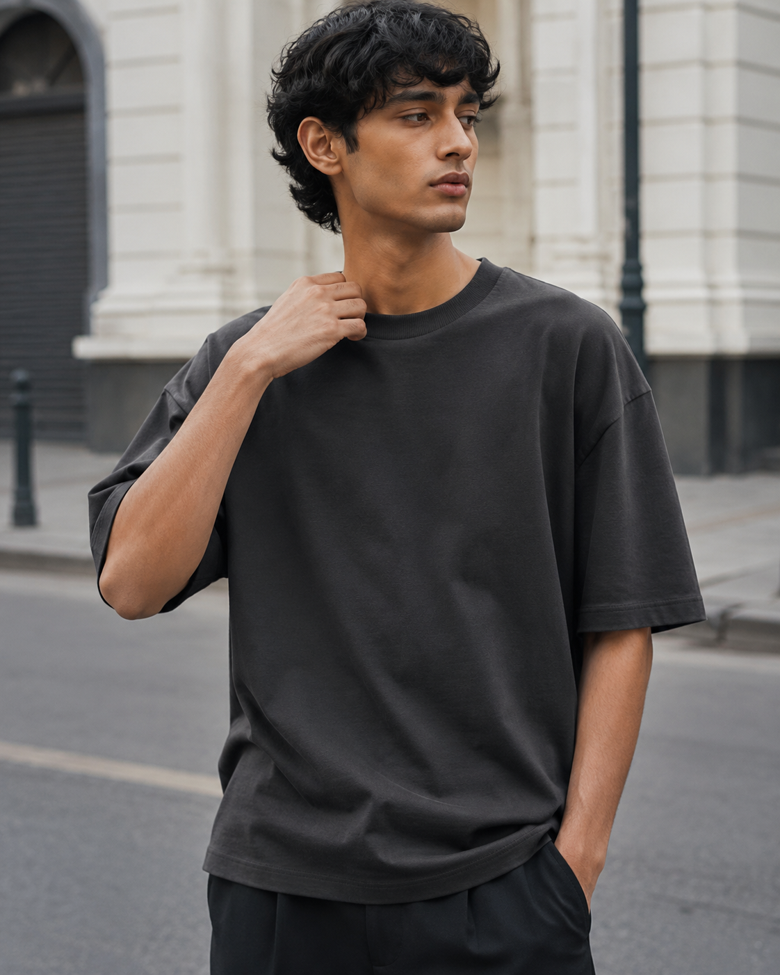Mid-length view of a male model wearing the RENQARA Onyx oversized t-shirt, showing the relaxed silhouette, drop shoulders, and soft drape.