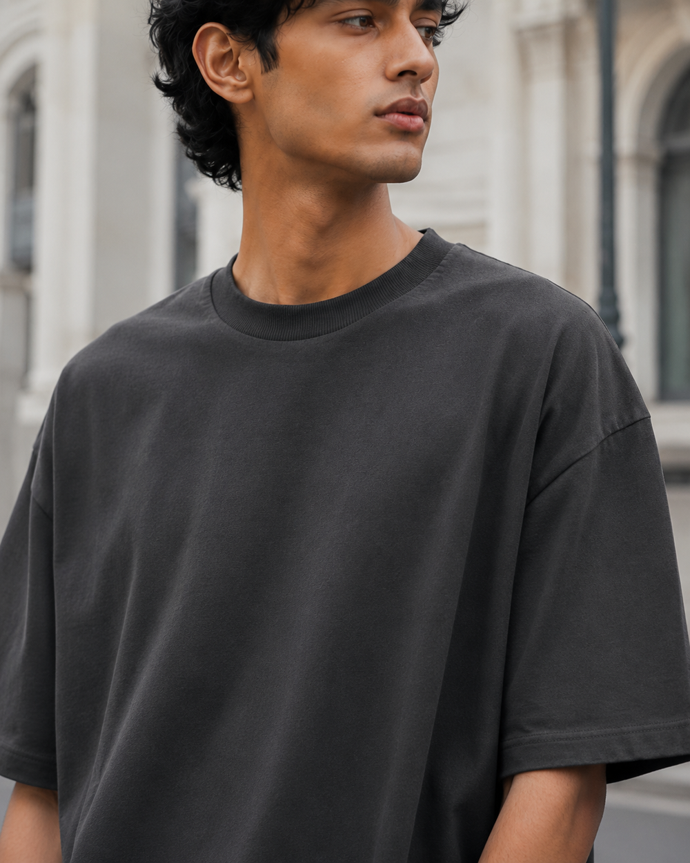Close-up of the RENQARA Onyx oversized t-shirt on a male model, highlighting the neckline, sleeve shape, and oversized fit.
