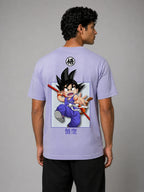 Back view of a male model wearing a lavender classic-fit cotton T-shirt against a light gray studio background, featuring a centered anime graphic of a young warrior character in motion with Japanese text below and a small circular symbol near the upper back.