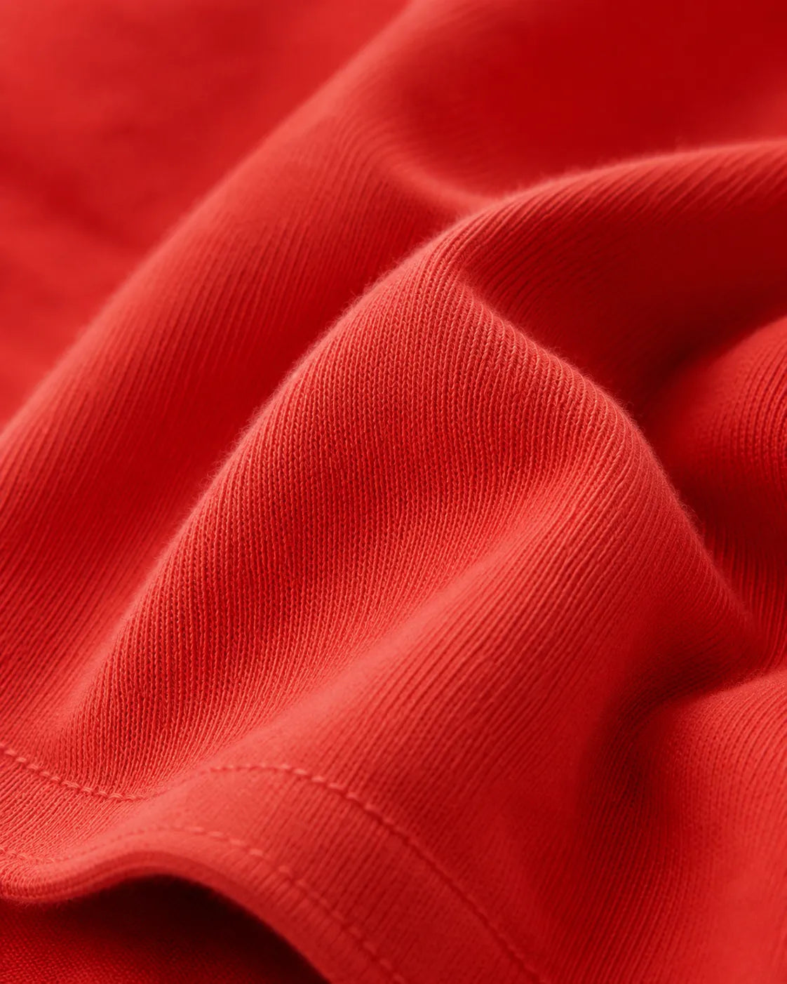 RENQARA Brick Red Oversized T-Shirt macro close-up showing cotton knit texture, fabric folds and stitching detail