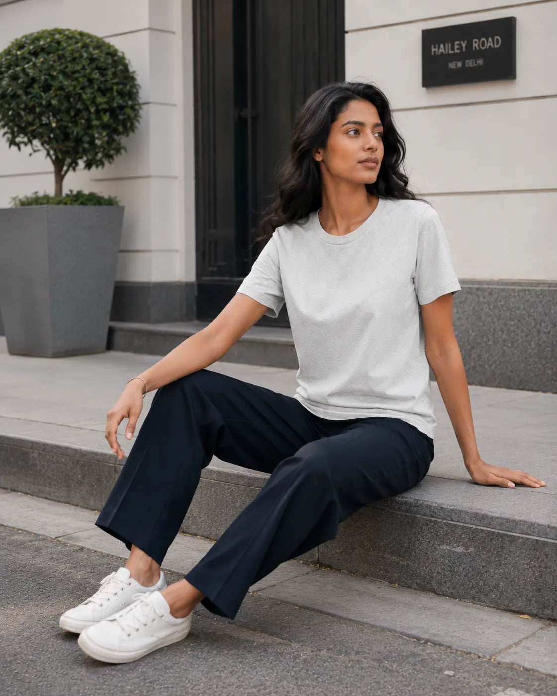 RENQARA Melange Grey Women’s Regular Fit T-Shirt seated lifestyle look styled with navy trousers and white sneakers