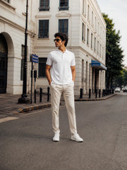 Full-body view of the RENQARA White Polo T-Shirt styled with cream trousers and white sneakers.