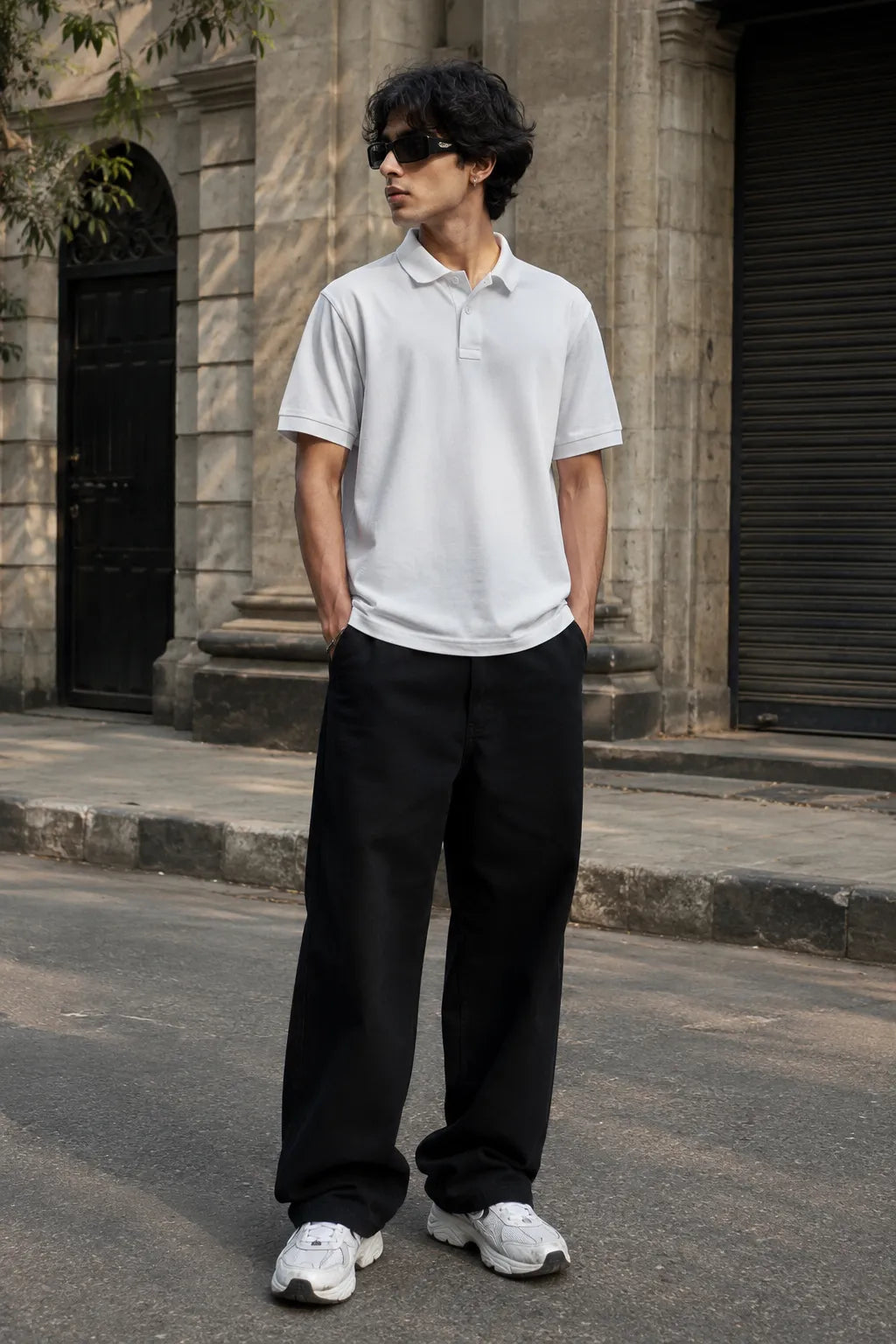 Model wearing the RENQARA White Polo T-Shirt crafted from premium 230 GSM piqué cotton with relaxed black trousers.