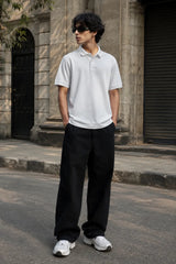 Model wearing the RENQARA White Polo T-Shirt crafted from premium 230 GSM piqué cotton with relaxed black trousers.