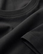 RENQARA Women’s Black Regular Fit T-Shirt close-up showing round neck rib, sleeve stitching and black cotton fabric texture