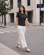 RENQARA Women’s Black Regular Fit T-Shirt worn in a clean street-style walking look with white trousers